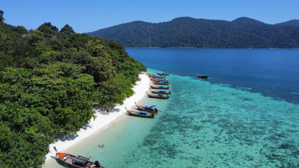 a group of boats sitting on top of a sandy beach