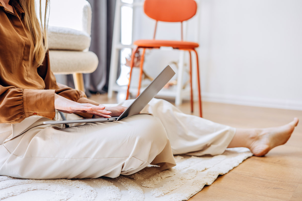 Young working mom working from home on her laptop