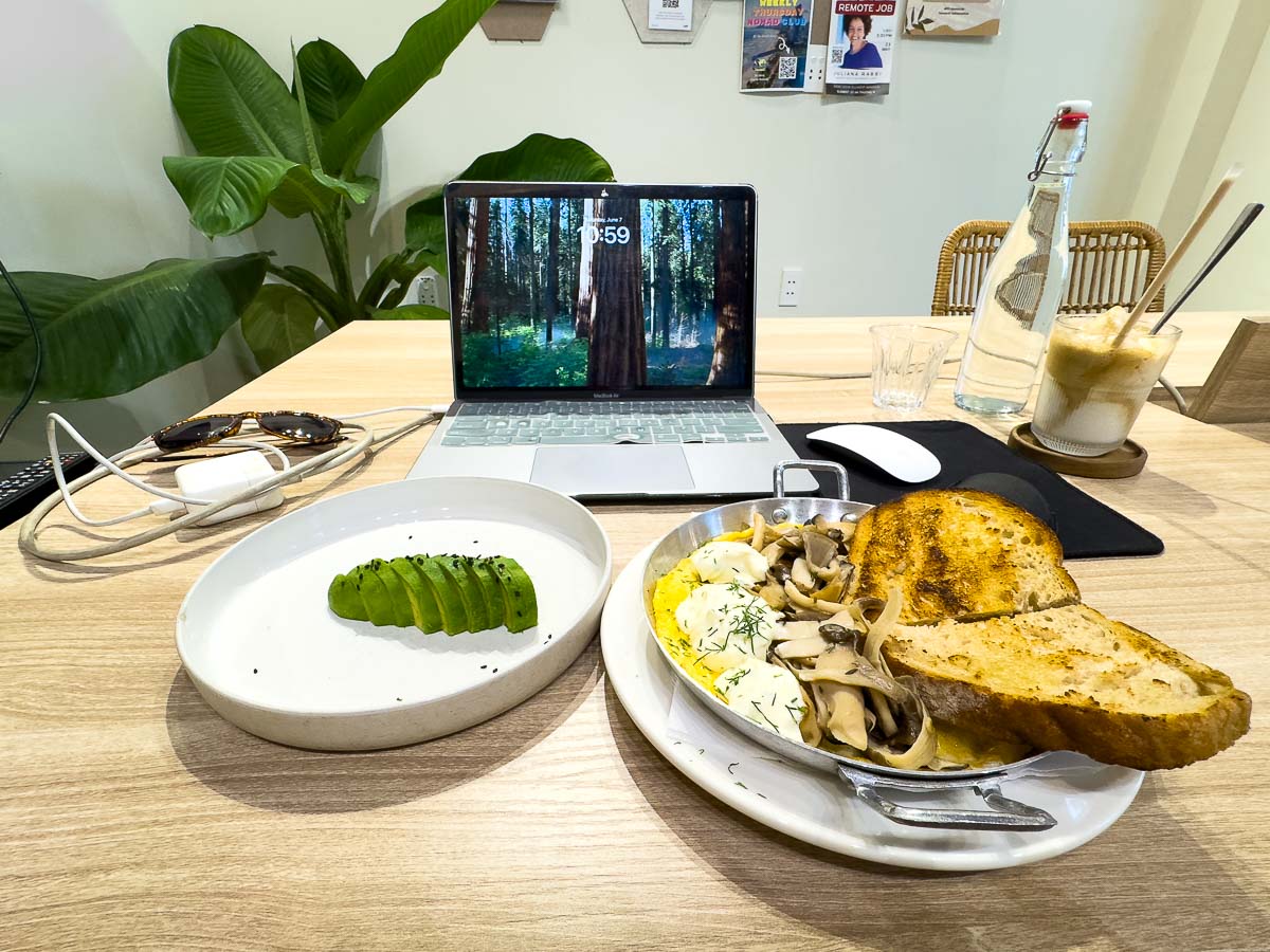 Coworking set up, my laptop, breakfast, and coffee.
