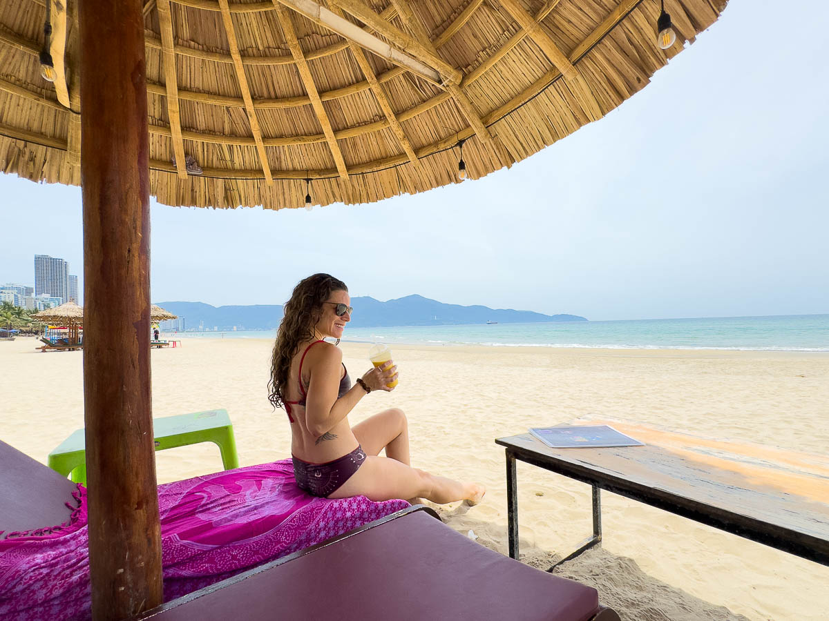 Nina under a wicker umbrella on the beach in Da nang, Vietnam.