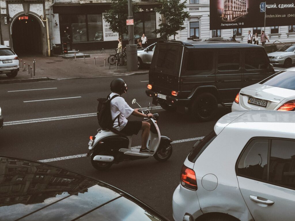 man wearing T-shirt riding on motor scooter