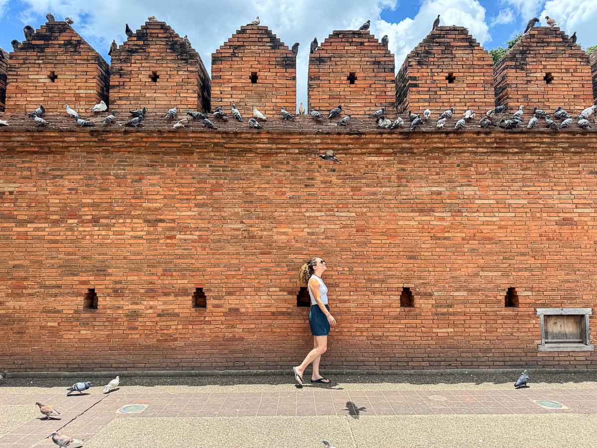 Chiang Mai Old Town brick wall with Nina walking by.