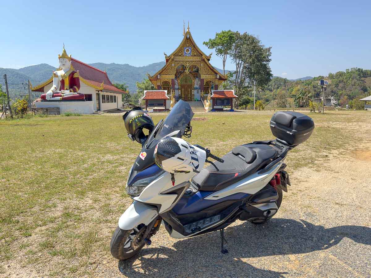 Our Honda Forza Motorcycle in front of temple.