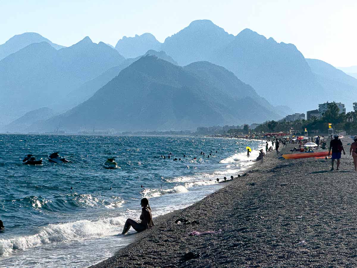 Rocky and sandy beach with mountain in the back in Antalya.