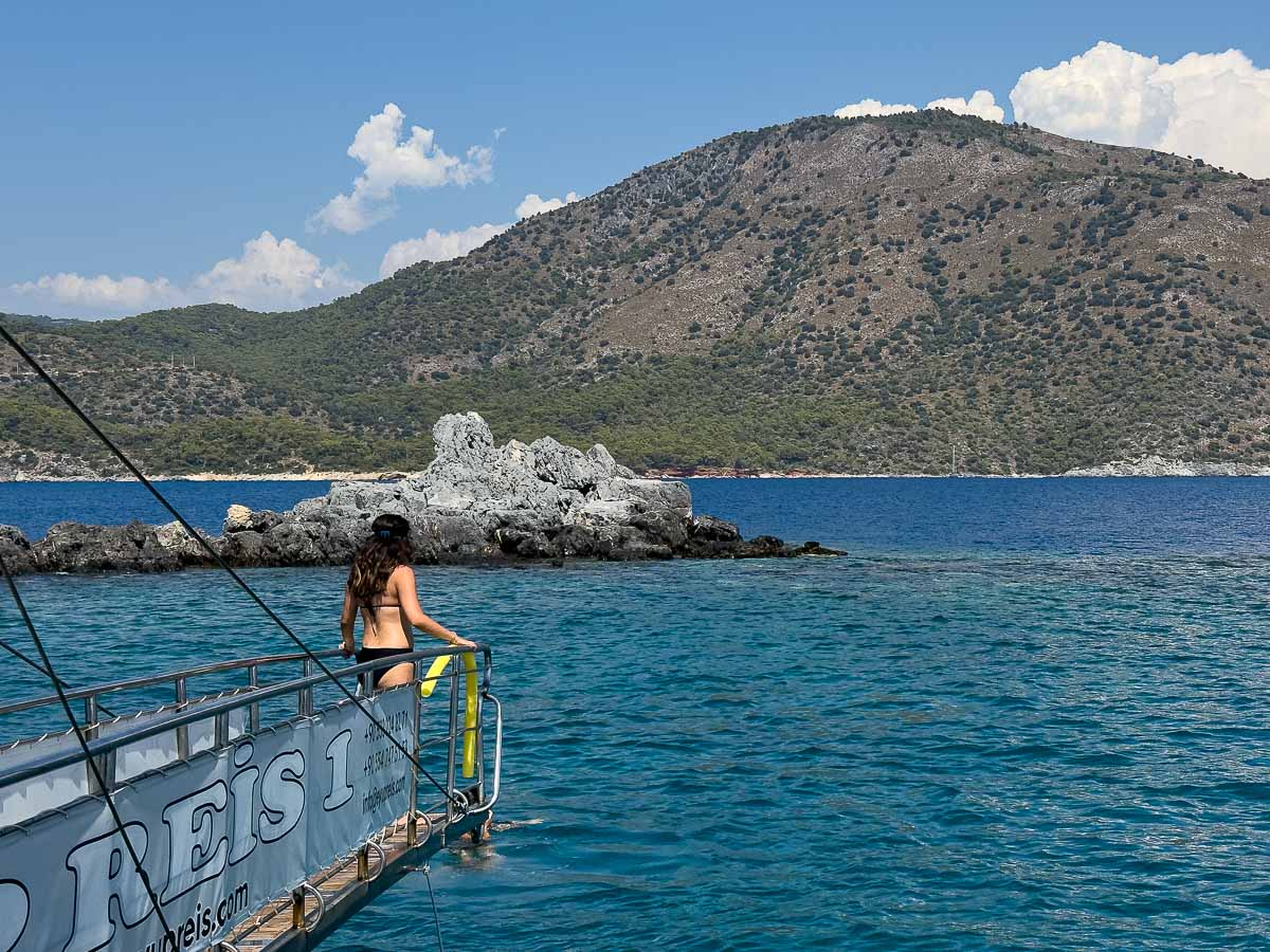 Woman on front of boat about to jump in water.
