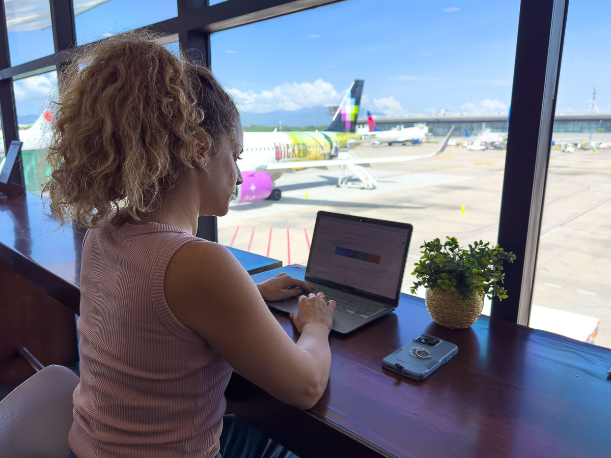 Nina at airport on laptop.