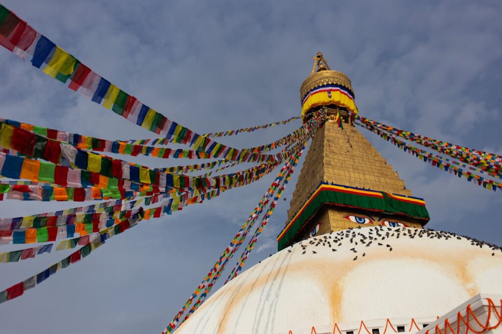 Colorful prayer flags drape over the iconic Boudhanath Stupa in Kathmandu, Nepal, a symbol of peace.