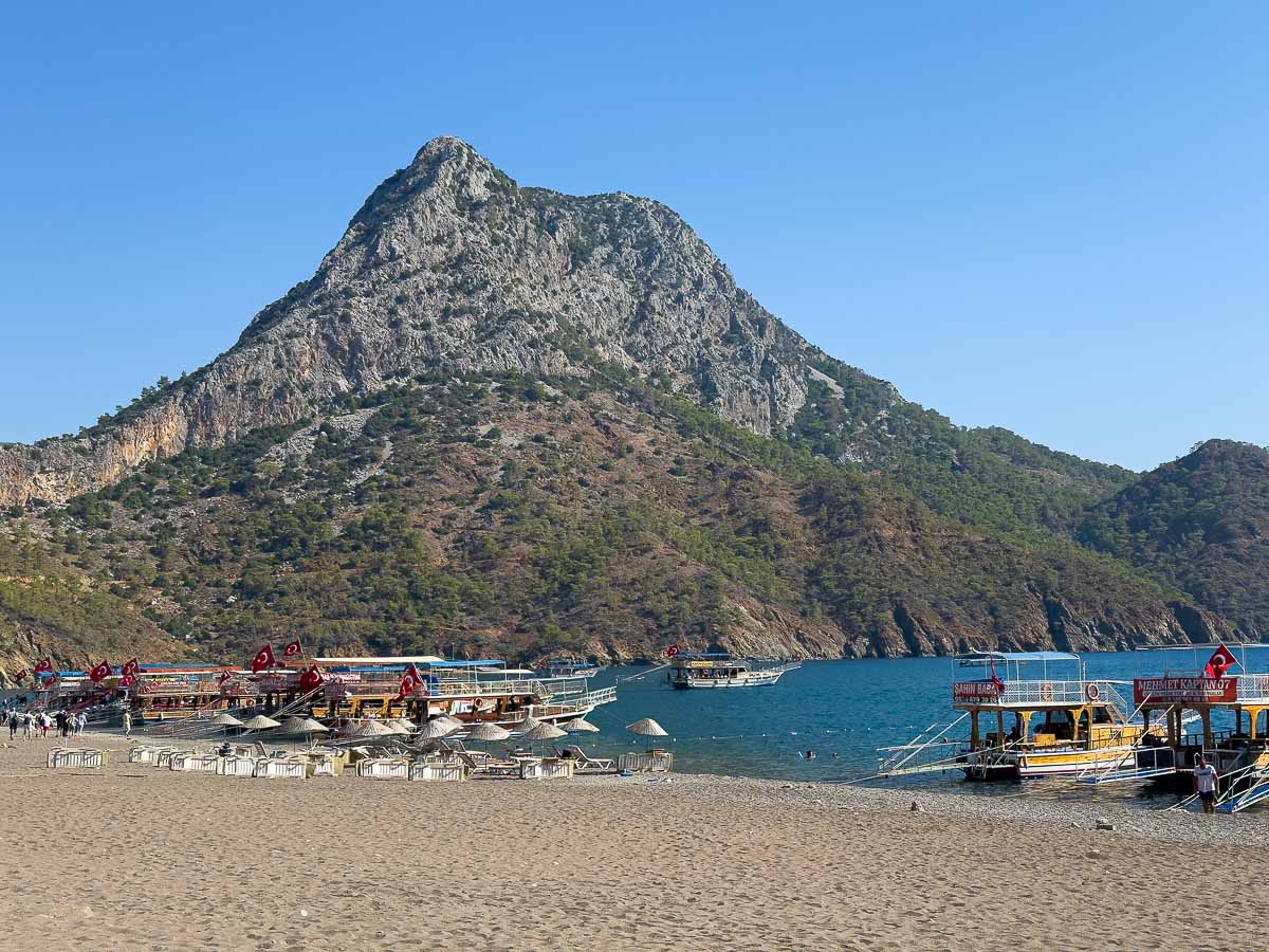 Beach with the boats and mountain in back.