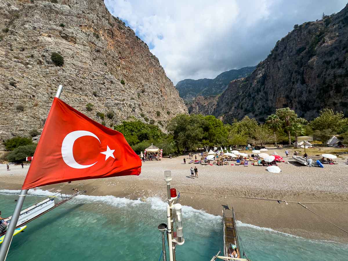 Turkey flag on boat docked at beach.