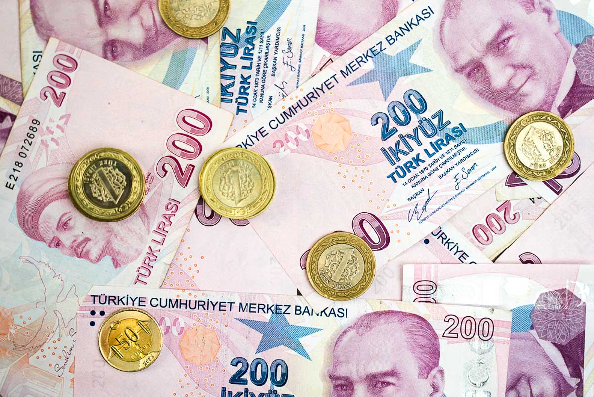 Close-up of Turkish lira banknotes and coins scattered on a flat surface. National currency of Turkey and economic background concept. Perfect for financial, investment, and economic analysis themes