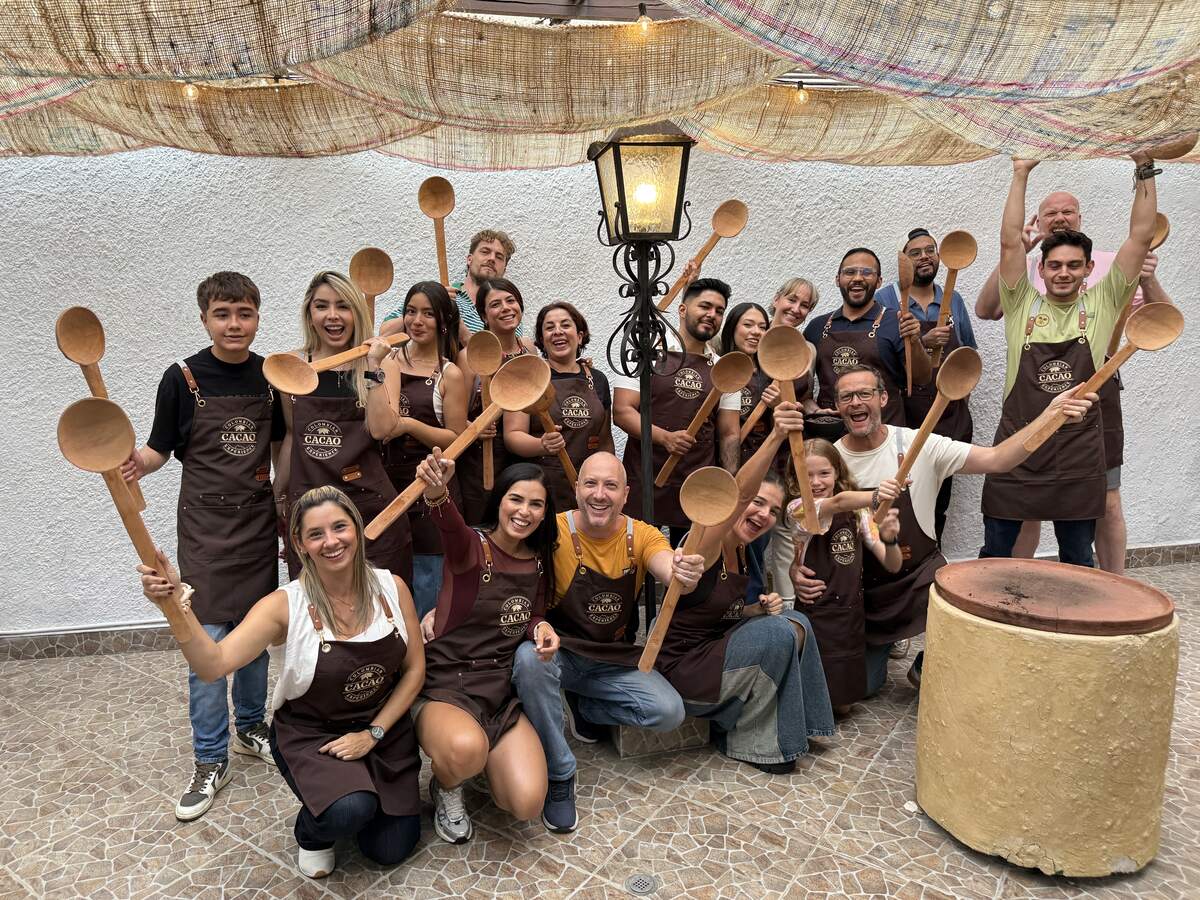 Colombian Cacao Experience group photo of people holding spoons.