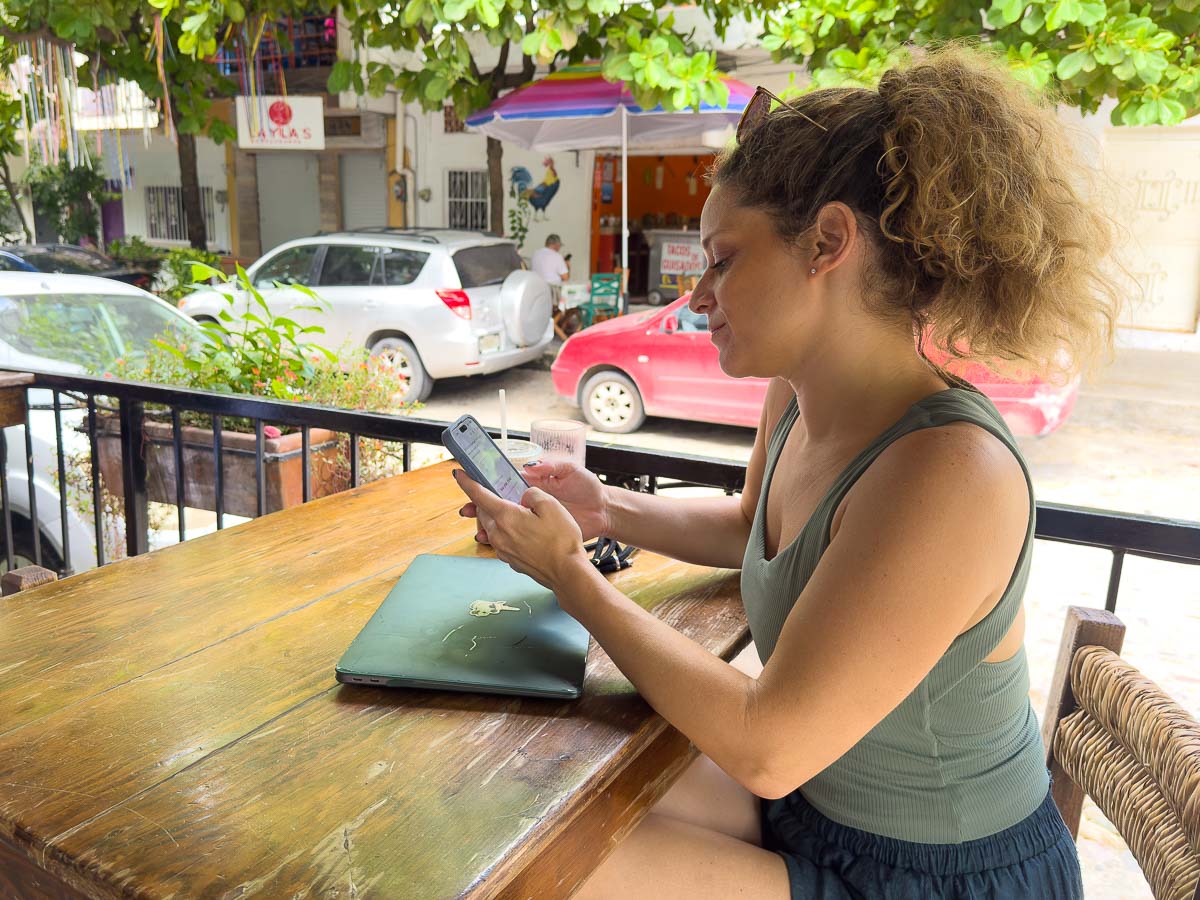 Nina on her phone at a cafe.