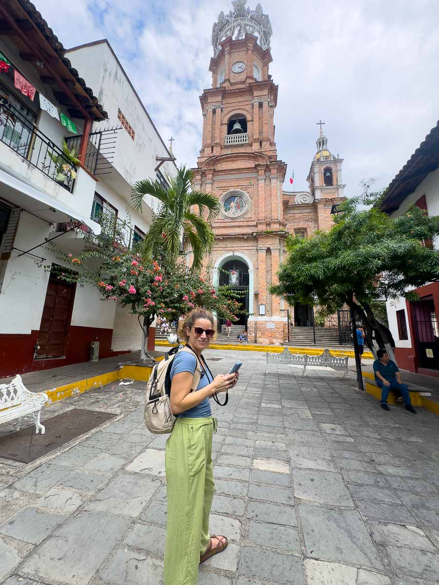 Nina on her phone outside a church in Mexico.