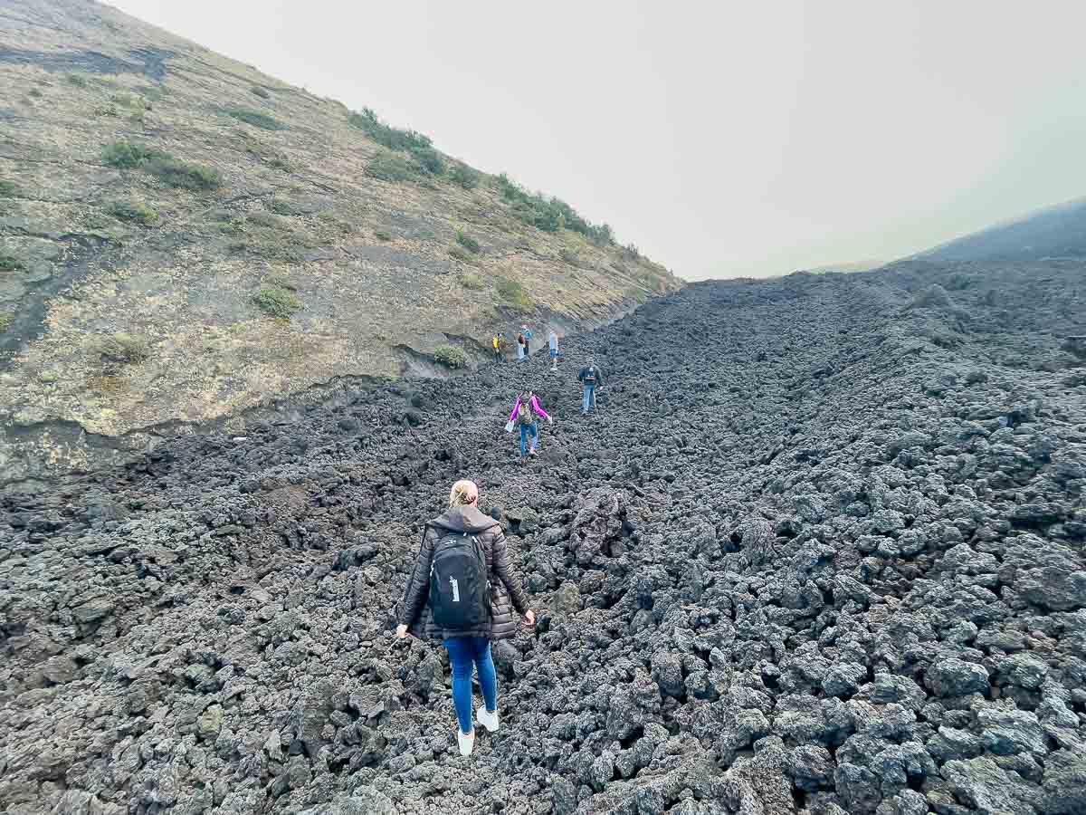 Rocky landscape with hikers on the Pacaya Volcano hike.