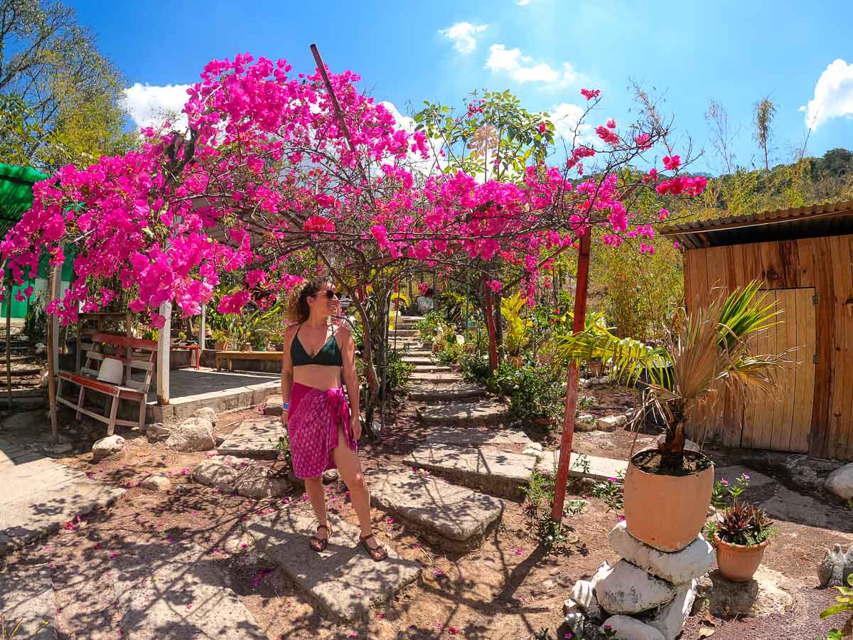 Nina standing with pink flowers.