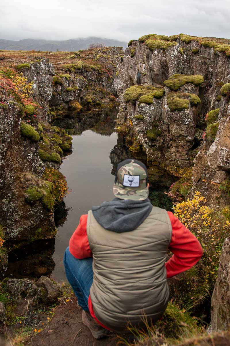 Garrett at hingvellir iceland looking at crack in the land.