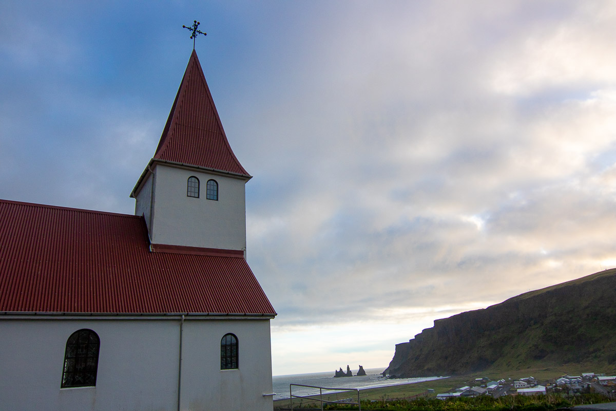 Church in Vik with red roof and ocean view.