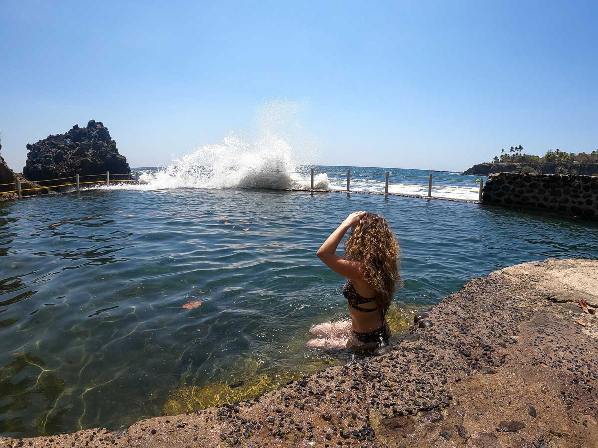 Nina at Atami ocean pools with wave crashing in the back.