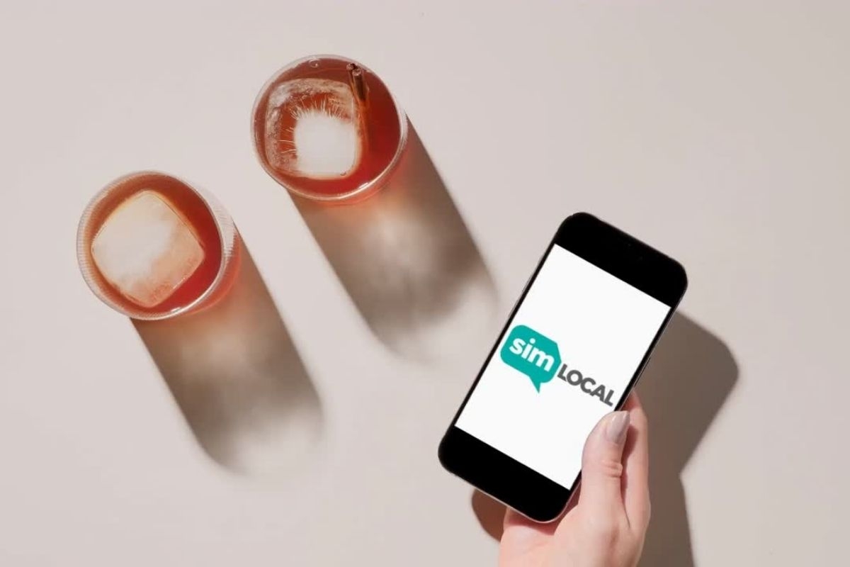 simlocal review showing a person holding a phone and two iced coffees