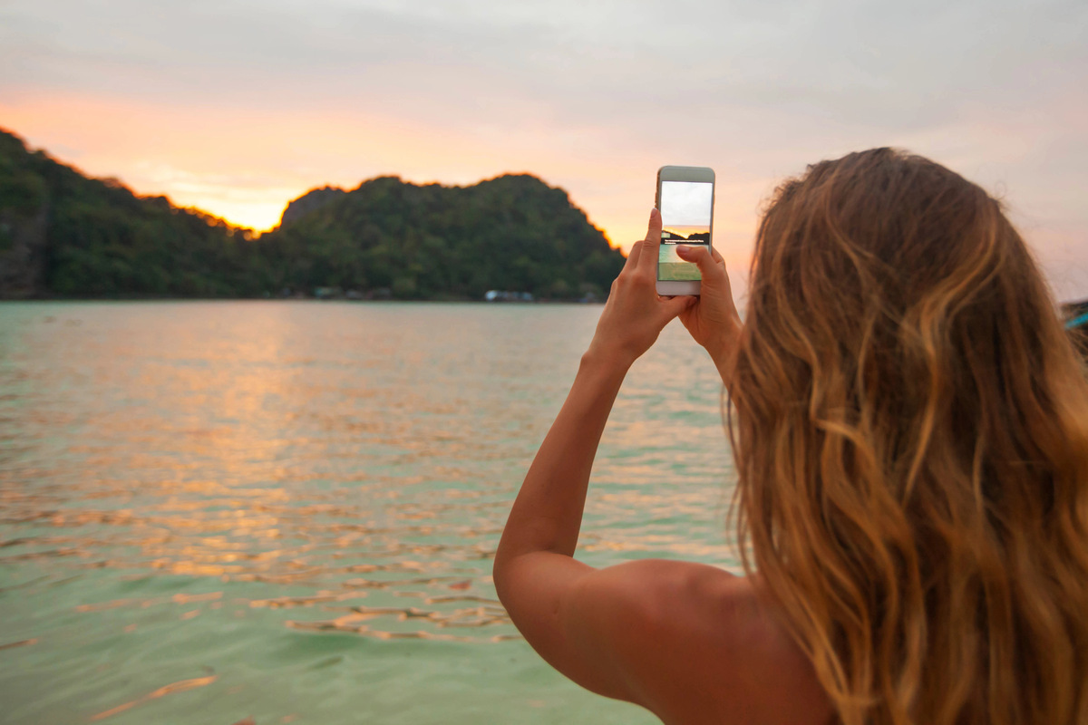 woman taking photo of island.