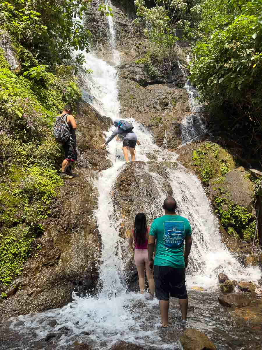 7 waterfalls hike people hiking up waterfall.