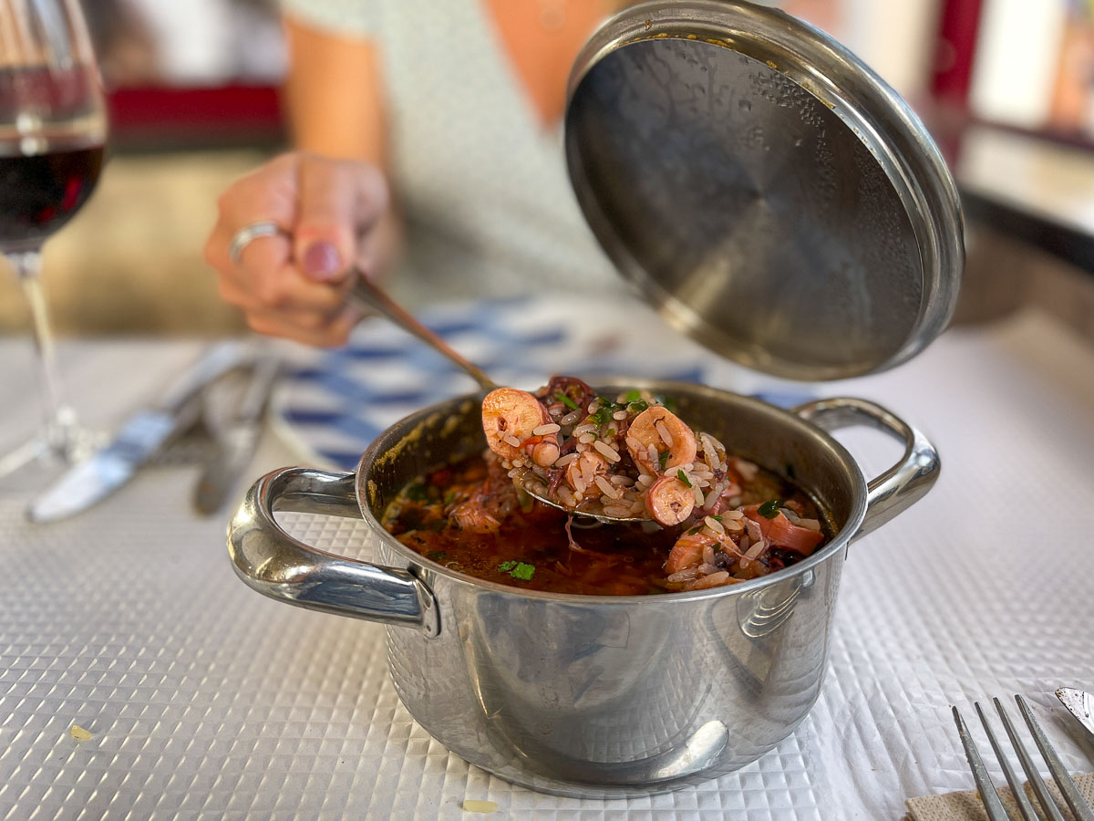 Nina spooning food out of a pot.