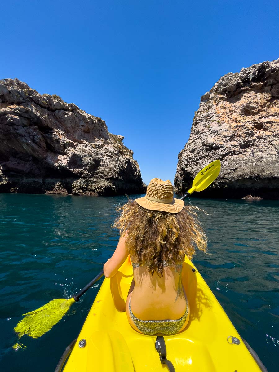 Nina in a kayak among rocks.