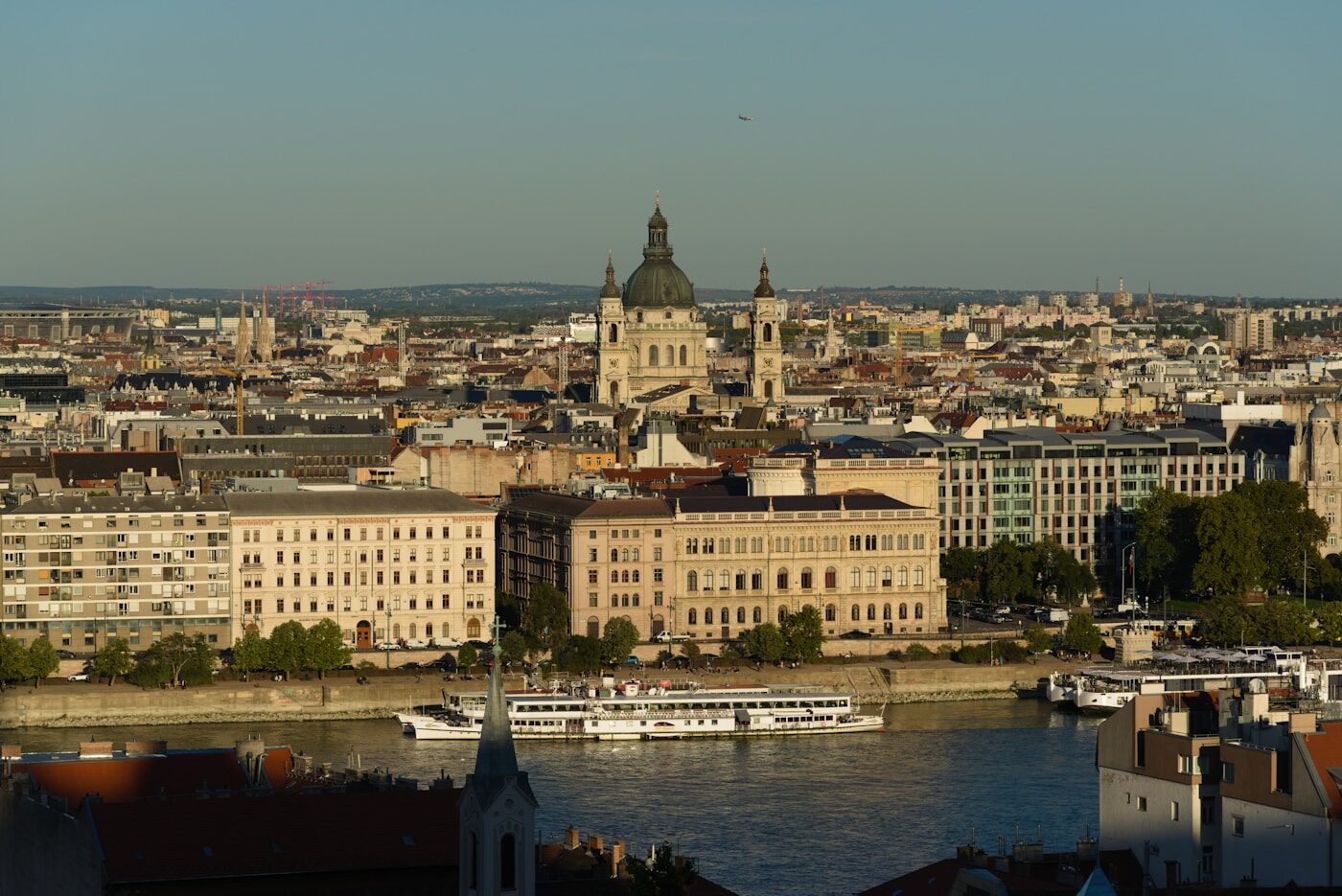 Cityscape with a river, boats, and a large domed building