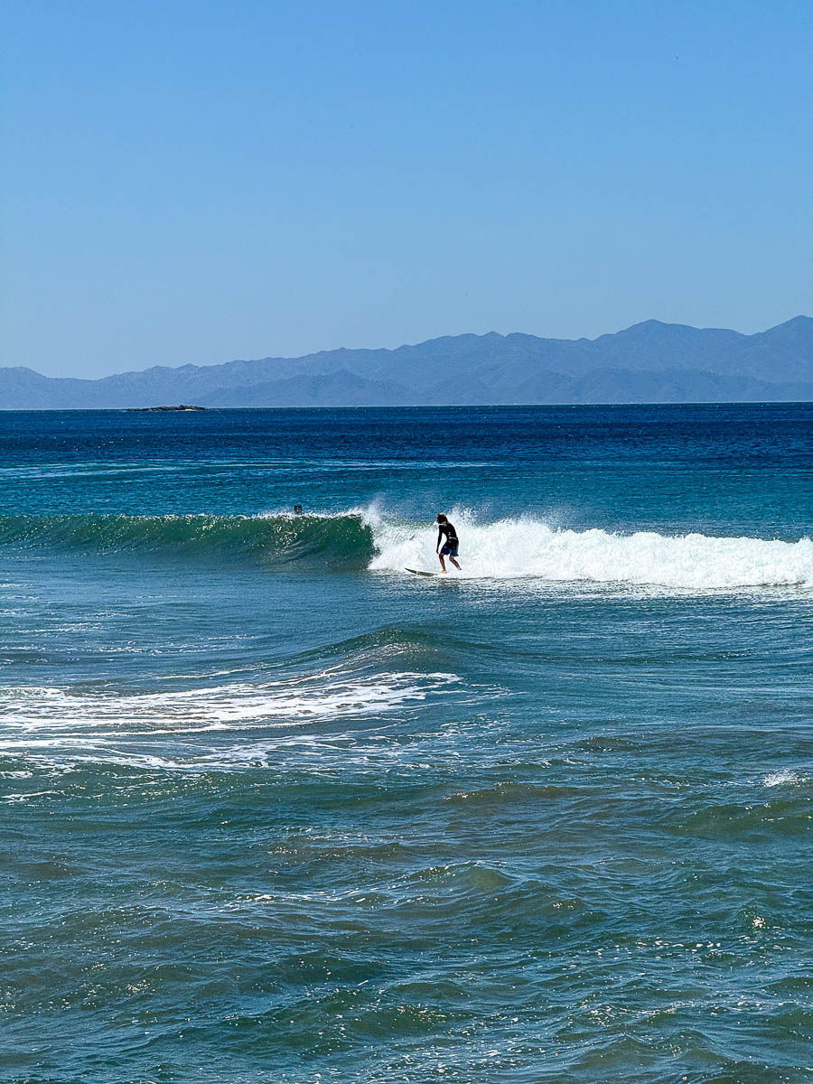 Lone surfer on the long, empty Playa El Coco