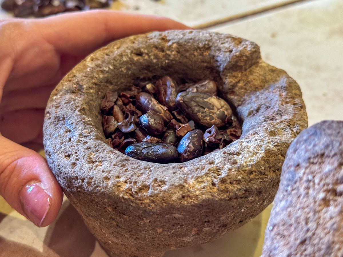 Grinding toasted cacao in a mortar at ChocoMuseo Granada
