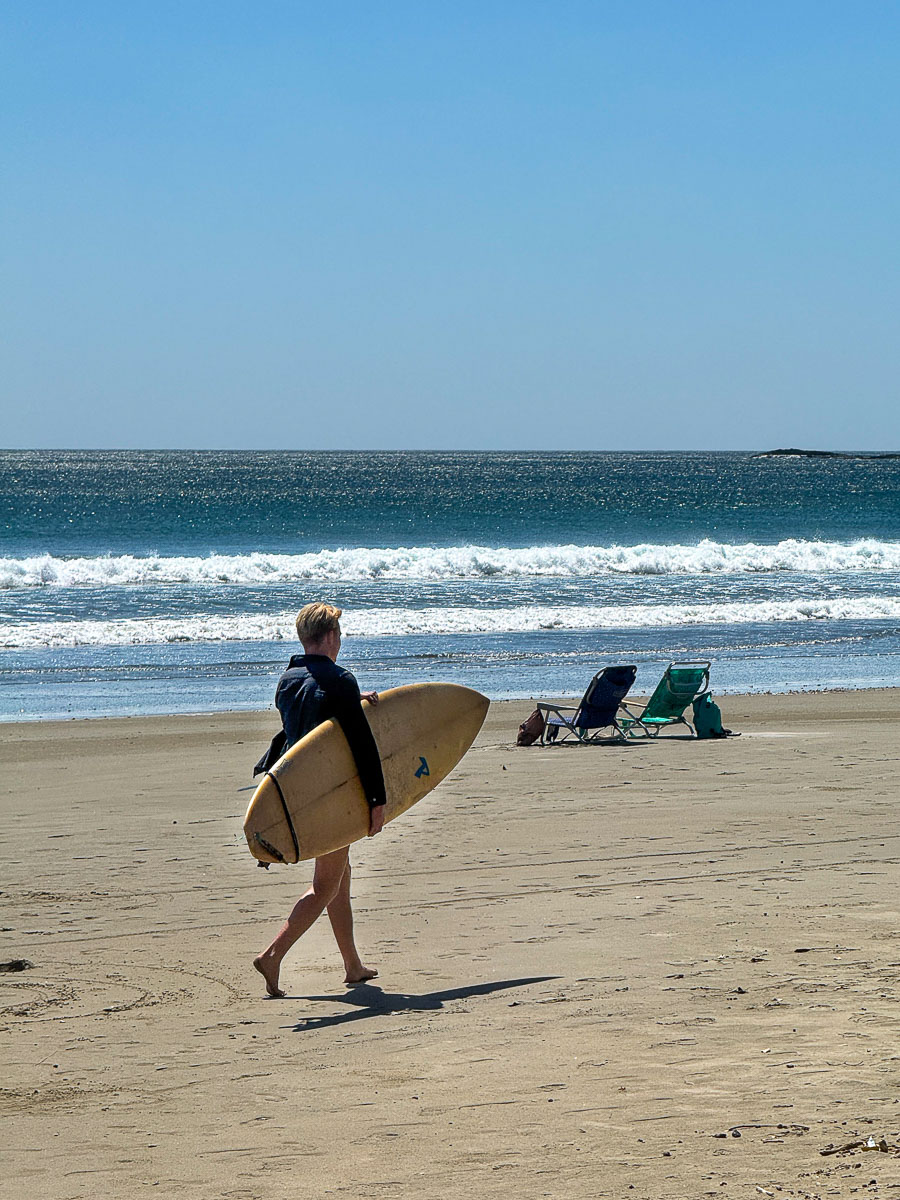 Surfer with a board on the huge, empty Playa Hermosa