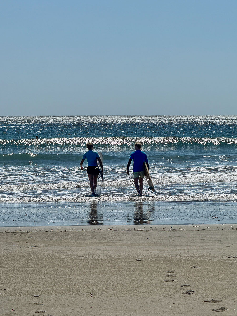 Two surfers walking to the water at Playa Hermosa, Nicaragua