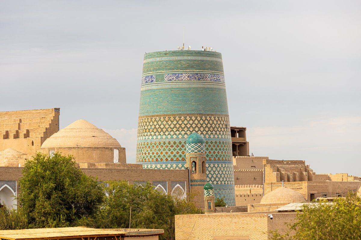 The turquoise Kalta Minor minaret above the rooftops of Itchan Kala in Khiva, Uzbekistan