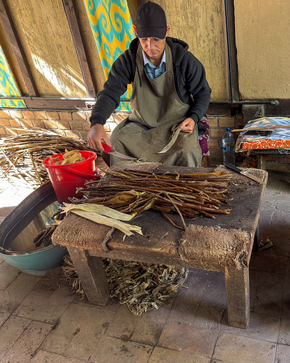Craftsman smoothing handmade mulberry silk paper at Koni Gil in Samarkand, Uzbekistan