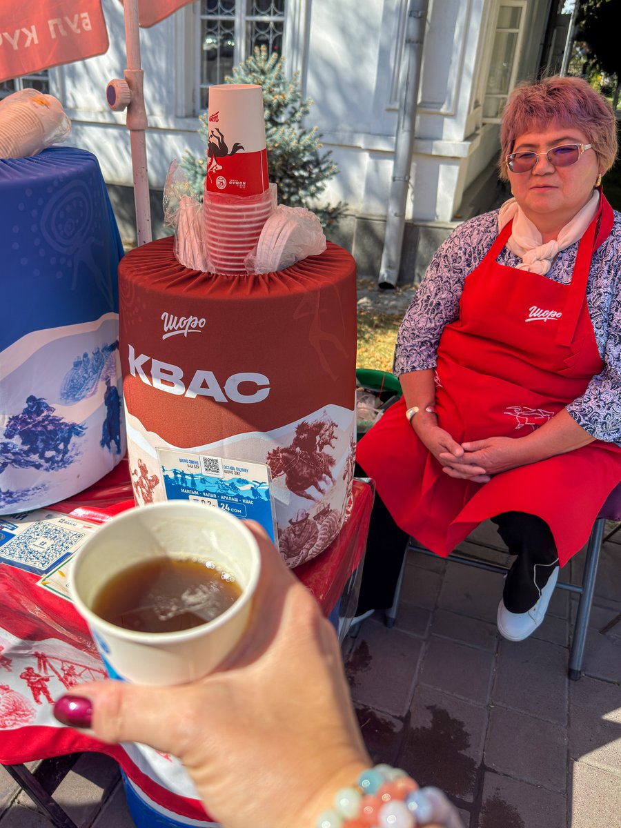Street vendor selling cups of kvas from a red barrel in Bishkek, Kyrgyzstan