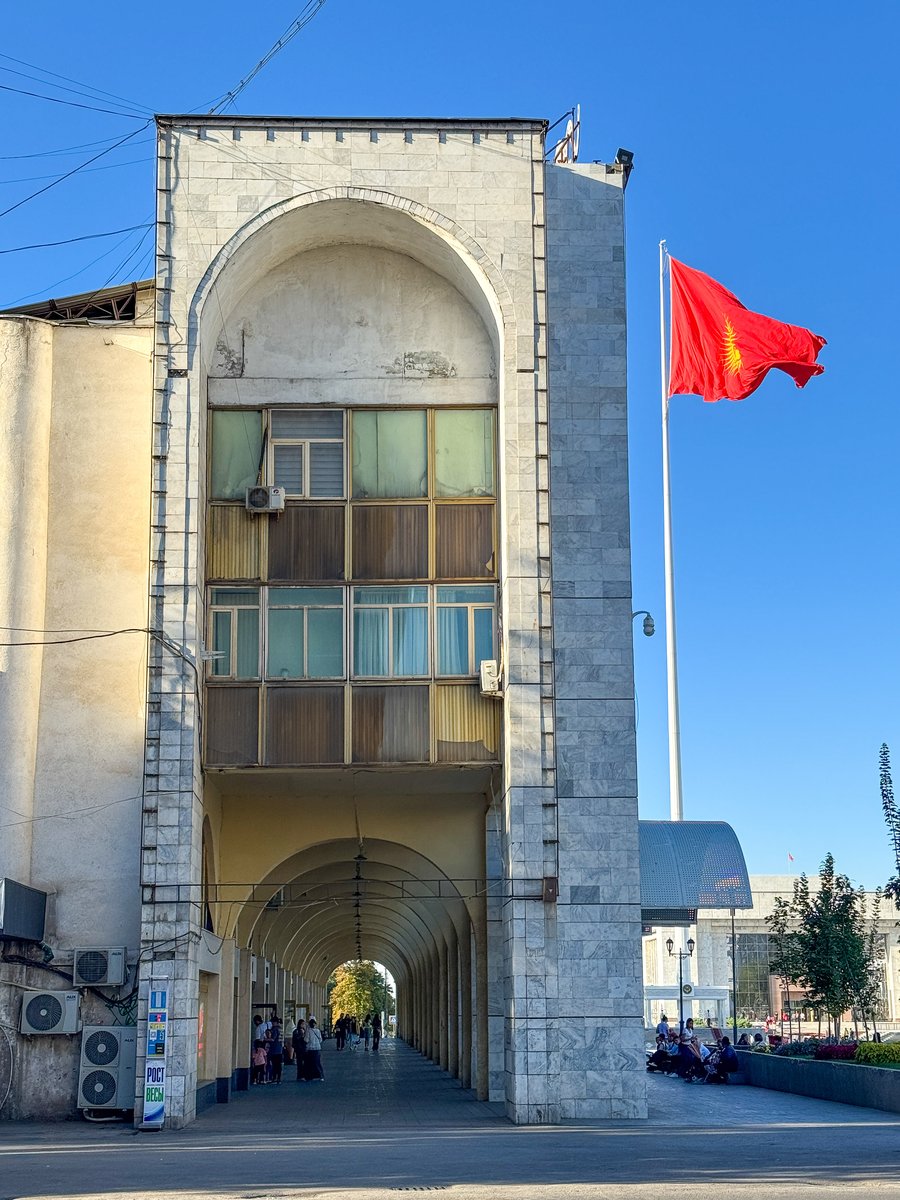 Kyrgyz flag flying beside a Soviet-era building in Bishkek, Kyrgyzstan