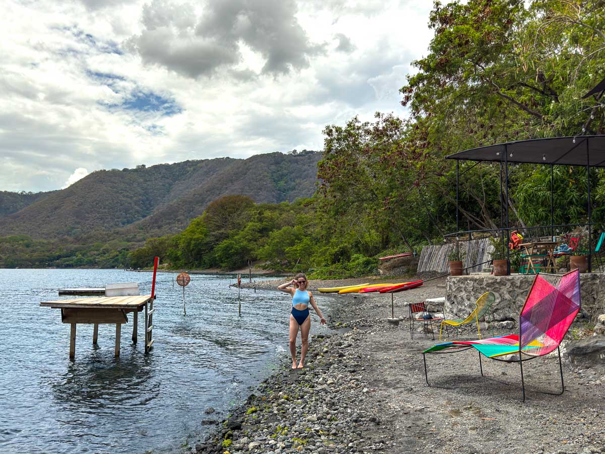 Nina by the water with chairs and kayaks at Laguna de Apoyo
