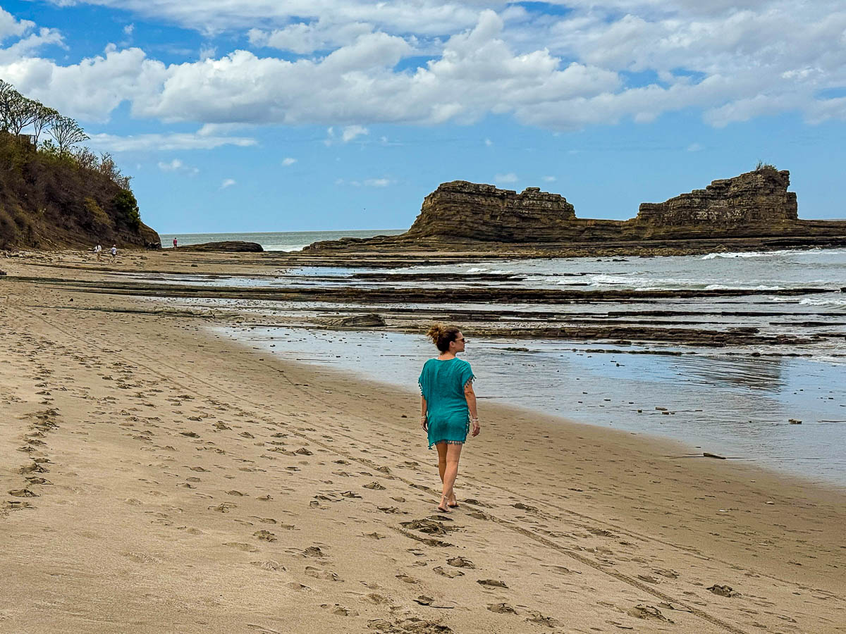 Nina walking the long beach toward Magnific Rock in Popoyo