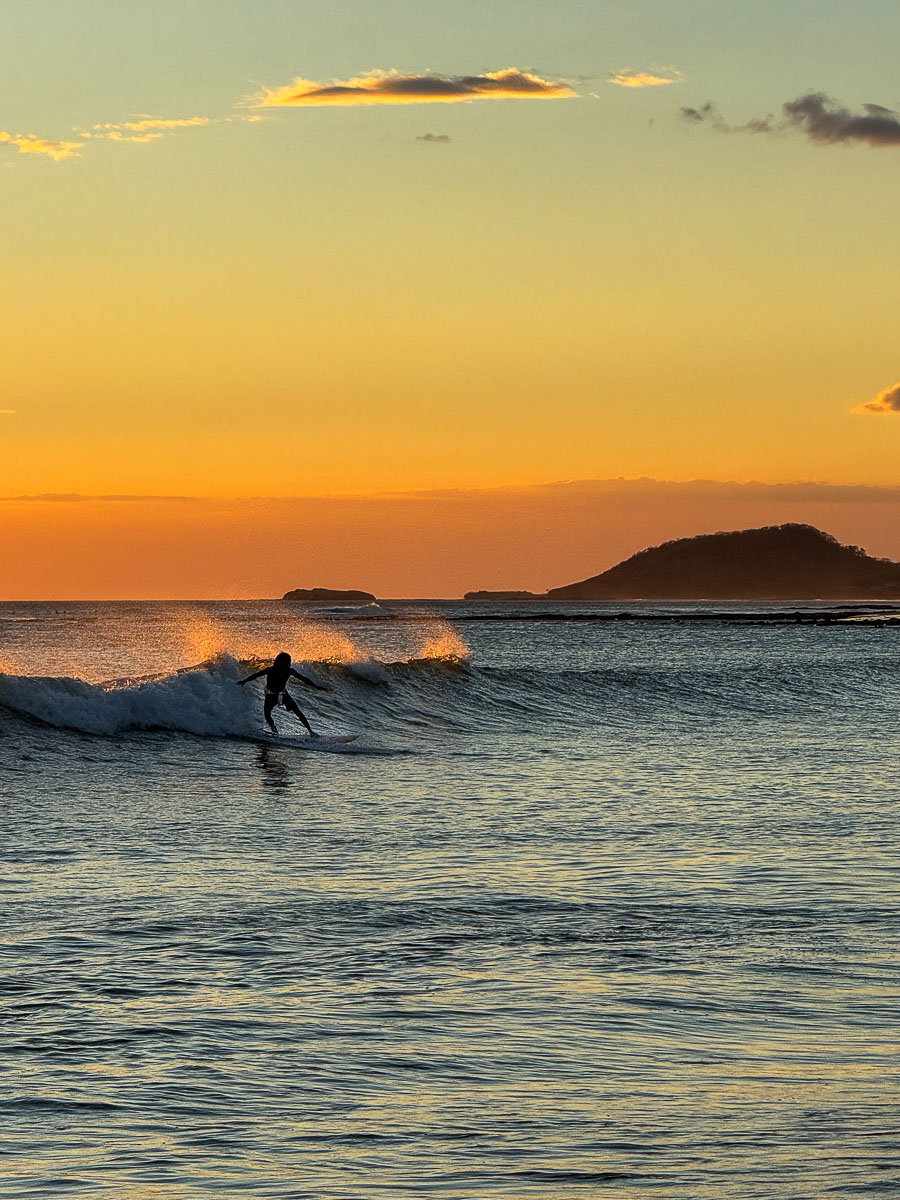 Surfer heading into the waves at sunset in Popoyo, Nicaragua