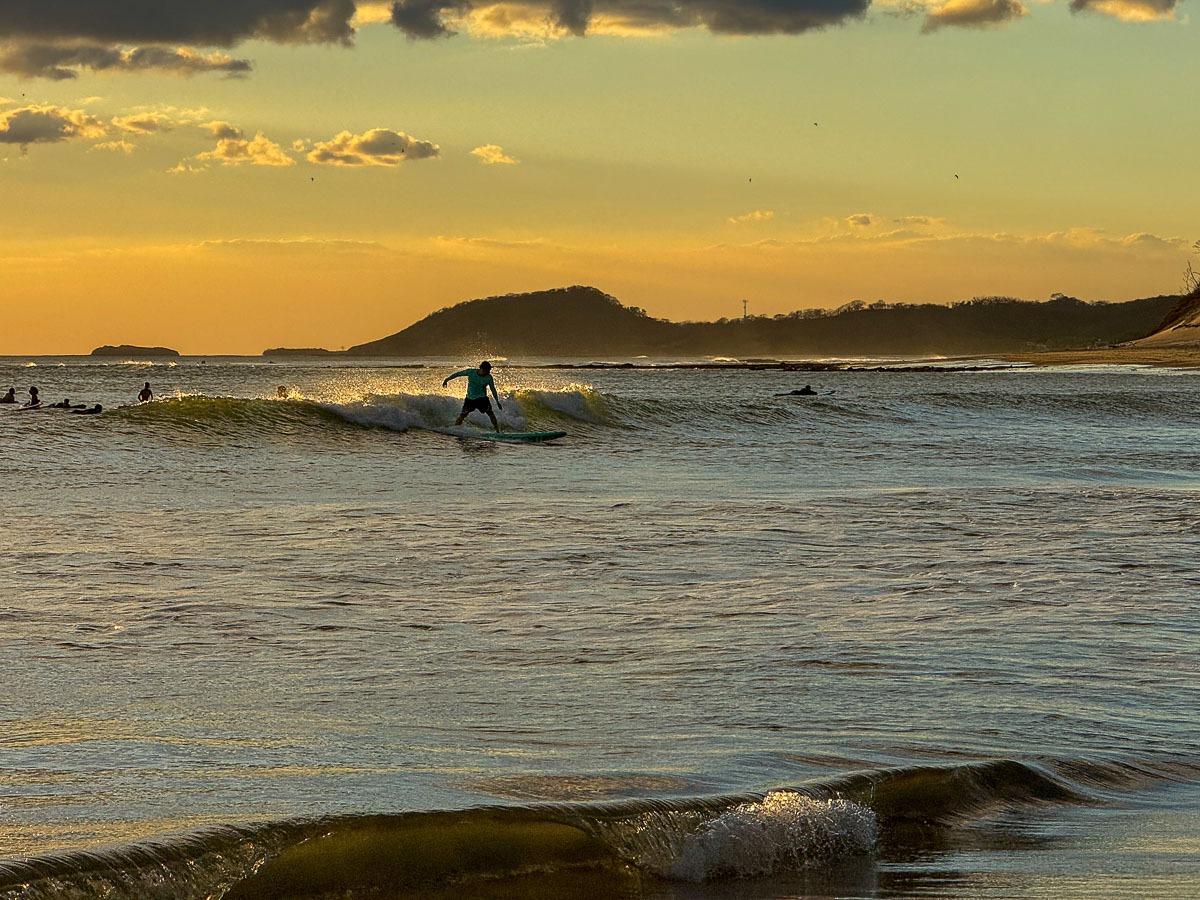 Surfer riding a wave at sunset in Popoyo, Nicaragua