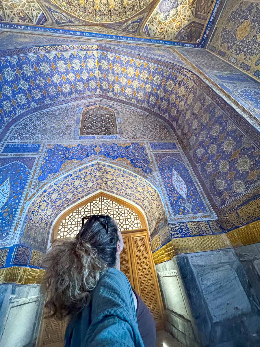 Nina looking up at the detailed ceiling inside Registan Square, Samarkand, Uzbekistan