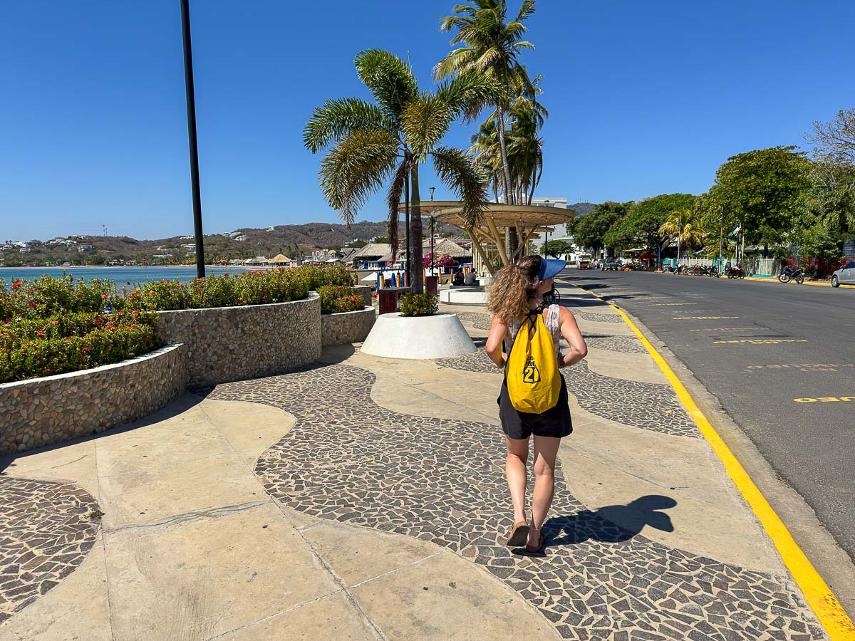 Nina walking the waterfront in San Juan del Sur with a dry bag