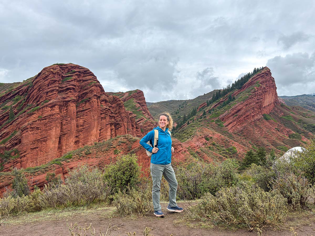 Nina in front of the red Seven Bulls rock cliffs at Jeti-Oguz, Kyrgyzstan