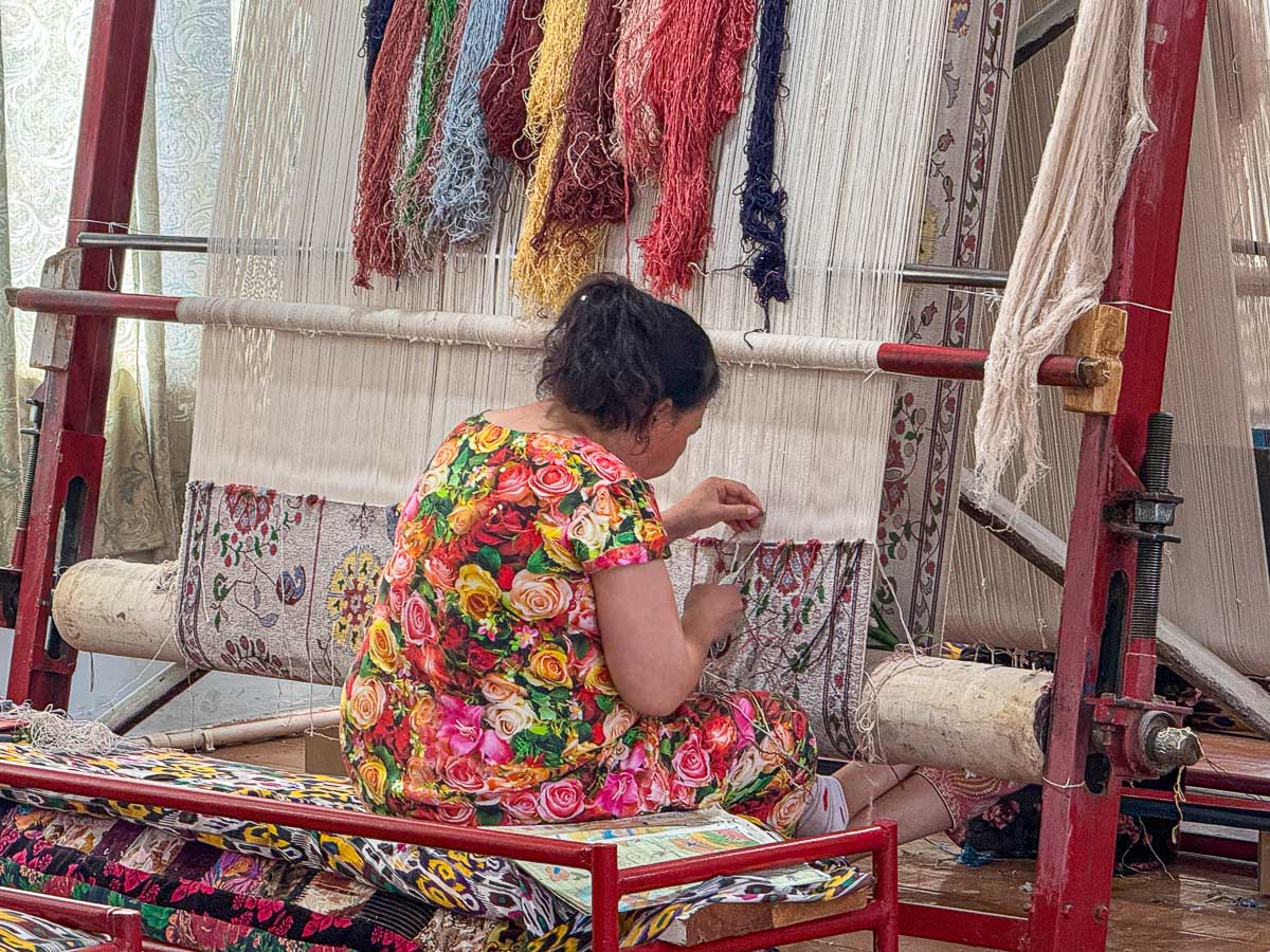 Woman weaving a silk carpet by hand at a workshop in Samarkand, Uzbekistan
