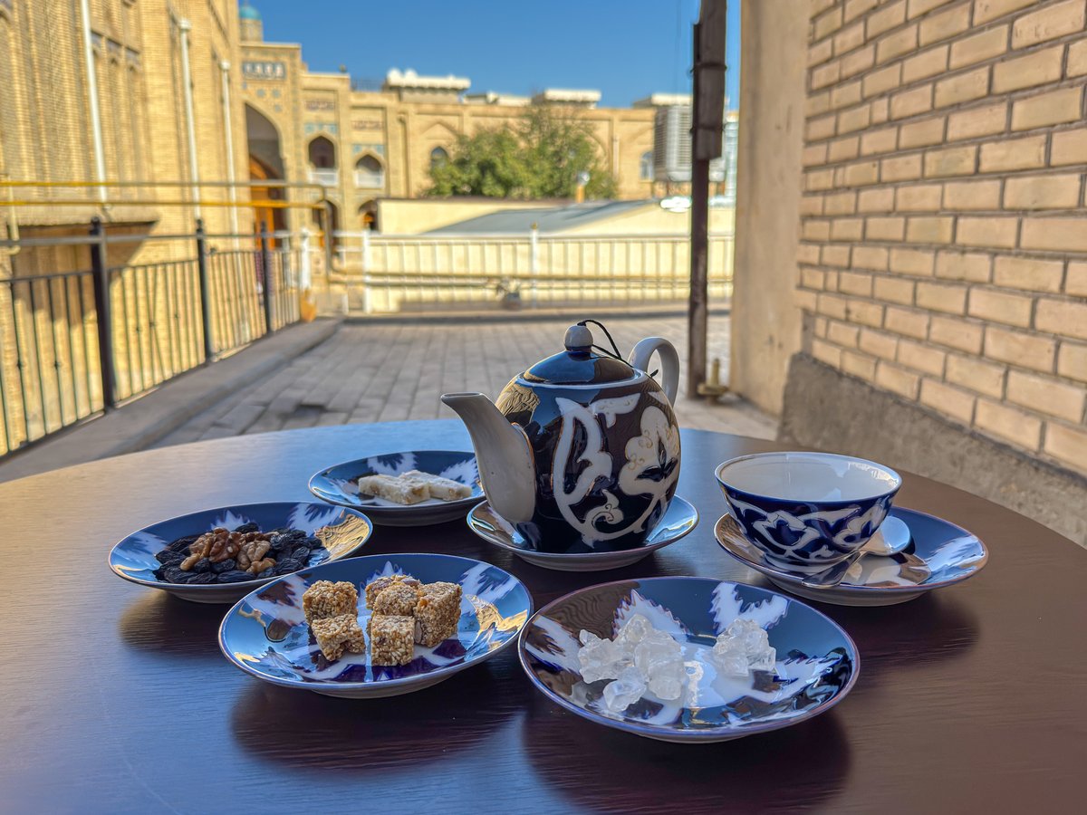 Tea set and local sweets on a table at the Silk Road Teahouse in Bukhara, Uzbekistan