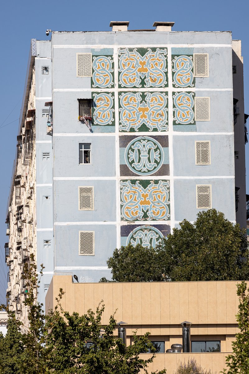 Mosaic-covered apartment building above a tree-lined street in Tashkent, Uzbekistan