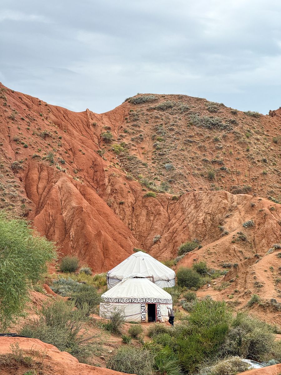 White yurt among red clay hills near Fairytale (Skazka) Canyon, Kyrgyzstan